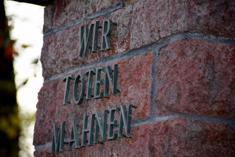 Inschrift "Wir Toten mahnen" auf einer Steinwand